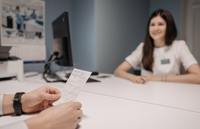 Woman doctor discussing patient's prescription in a clinic office setting.