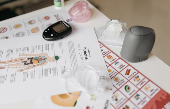 A comprehensive flat lay of diabetes management tools including a glucose meter and instructional flyers.