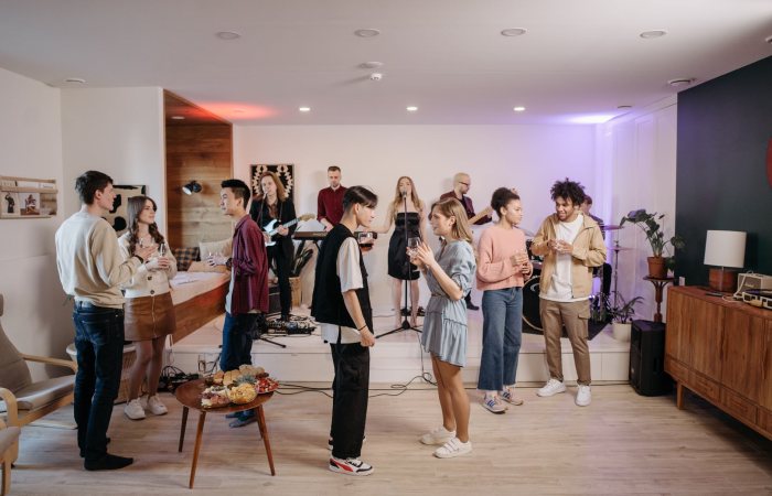 A vibrant indoor party atmosphere with friends enjoying live music and conversations.