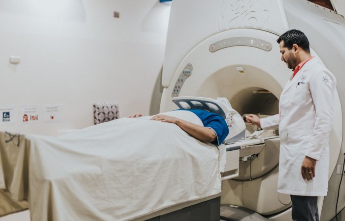A doctor assists a patient during an MRI scan in a hospital setting, highlighting modern healthcare technology.