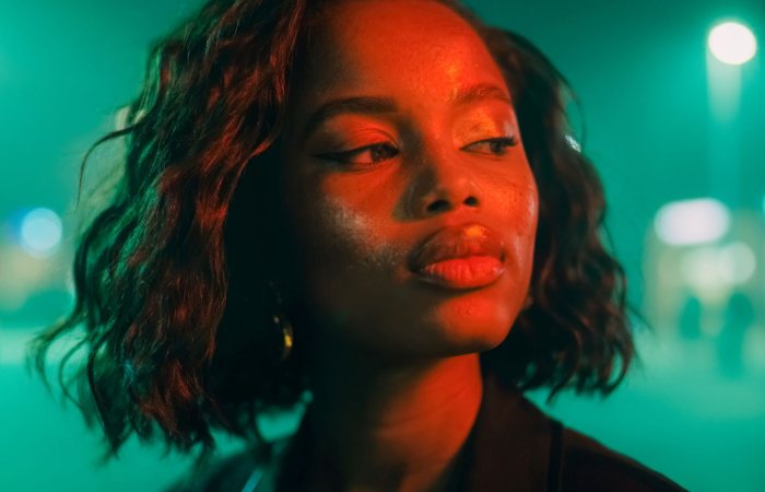 Captivating portrait of a woman under vibrant neon lighting, evoking a moody and artistic feel.